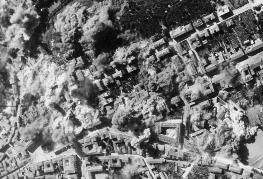 Royal Air Force- Italy, the Balkans and South-east Europe, 1942-1945. Vertical aerial photograph showing bombs from aircraft of the Tactical Bomber Force exploding in the town of Avellino, near Naples, before its capture by troops of the American 5th Army.