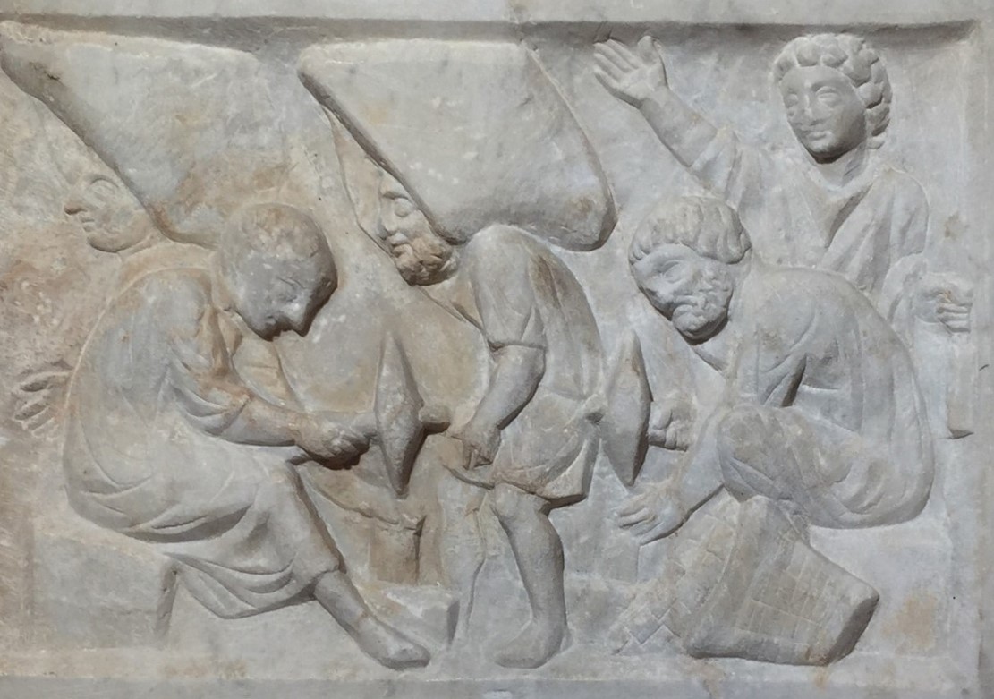 Marble funerary relief for a mosaic-maker, found at the necropolis of the Isola Sacra near ancient Ostia. Late IIIrd / early IVth century CE. The relief shows craftsmen at work cutting tesserae to set into a mosaic. - Ancient Ostia, Antiquarium at the Parco Archeologico di Ostia Antica. It was perhaps placed at the end of a locus and is supposed to show mosaicists preparing tesserae, in memory of the profession of the deceased.