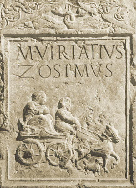 Funerary slab (1st century CE) belonging to a larger monument. The deceased is seated on a fast travel chariot (raeda) with a charioteer (auriga), a young man holding the whip and reins. The funerary monument was made by Viriatius Zosimus, a freedman, most likely for his master, who must have also been the commissioner. The stele has an ambiguous meaning, wavering between the depiction of a real-life scene, related to the deceased's profession, and a journey to the world of the dead. The scene is depicted within the epigraphic field and below the inscription. Between the legs of the horse pulling the chariot, a small dog is represented. Above the epigraphic field, there is a pediment framed by a flat band moulding and decorated inside with two opposing dolphins intertwining their tails around a central trident. - Archaeological Museum, Verona, Italy